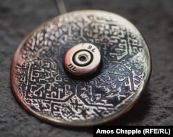 A brooch with traditional Armenian patterns that was made from a bullet casing