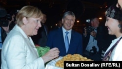 Канцлер Германии Ангела Меркель (слева) и президент Кыргызстана Алмазбек Атамбаев (в центре). Бишкек, 14 июля 2016 года.
