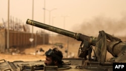 A rebel drives his tank to the frontline in Ajdabiya today.