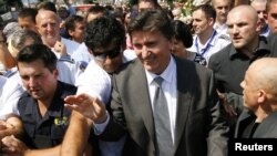 Former Bosnian wartime leader Ejup Ganic is greeted by a crowd as he arrives at Sarajevo airport on July 28.