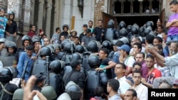 Police move into a mosque during clashes with supporters of deposed Egyptian President Muhammad Morsi inside a room of the Al-Fath Mosque in Cairo on August 17.