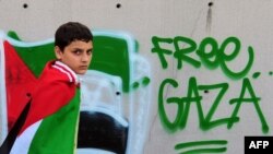 A boy wears a Palestinian flag on his shoulders during an anti-Israeli protest in front of the Israeli Consulate in Istanbul today.