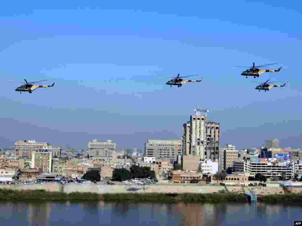 Iraqi military helicopters fly past the bombed-out Communications Ministry, destroyed during the 2003 invasion. - Photo by AFP