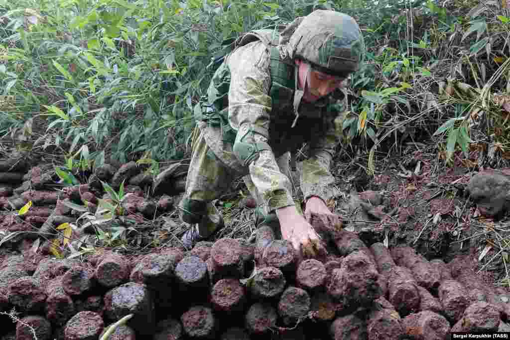 A member of the expedition in military uniform stacks the artillery shells. Handling such time-ravaged ordnance is risky, as detonators inside can decay over time, leaving the explosive on a hair trigger. In 2010, three experienced disposal experts were killed in Germany while trying to defuse a WWII-era bomb.