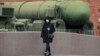 A woman wearing a face mask during a coronavirus lockdown walks past a Russian intercontinental ballistic missile launcher displayed at the Artillery Museum in St. Petersburg. 