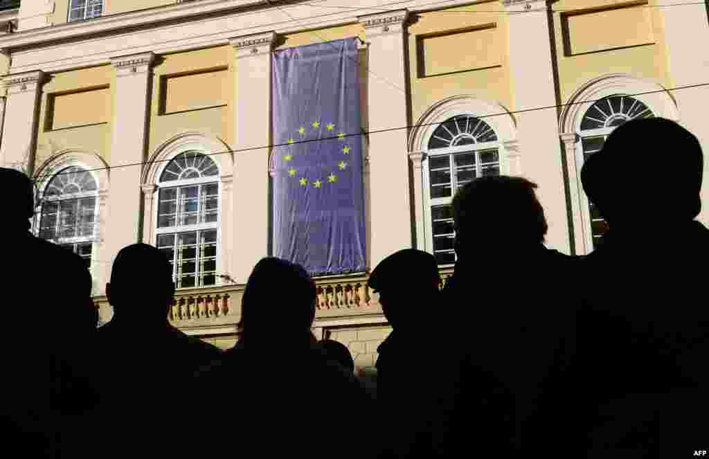 Ukrainians gather around an EU flag on the town hall of the western city of Lviv on November 20. (AFP/Yuriy Dyachshyn)