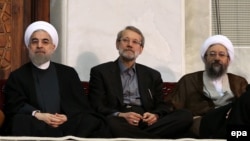 Iranian President Hassan Rohani (left) and judiciary chief Sadegh Larijani (right, with parliament speaker Ali Larijani in between) have traded barbs over the arrest of a billionaire.
