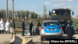 Силовики и работники в защитной одежде на блокпосту в Шымкенте. 2 апреля 2020 года.