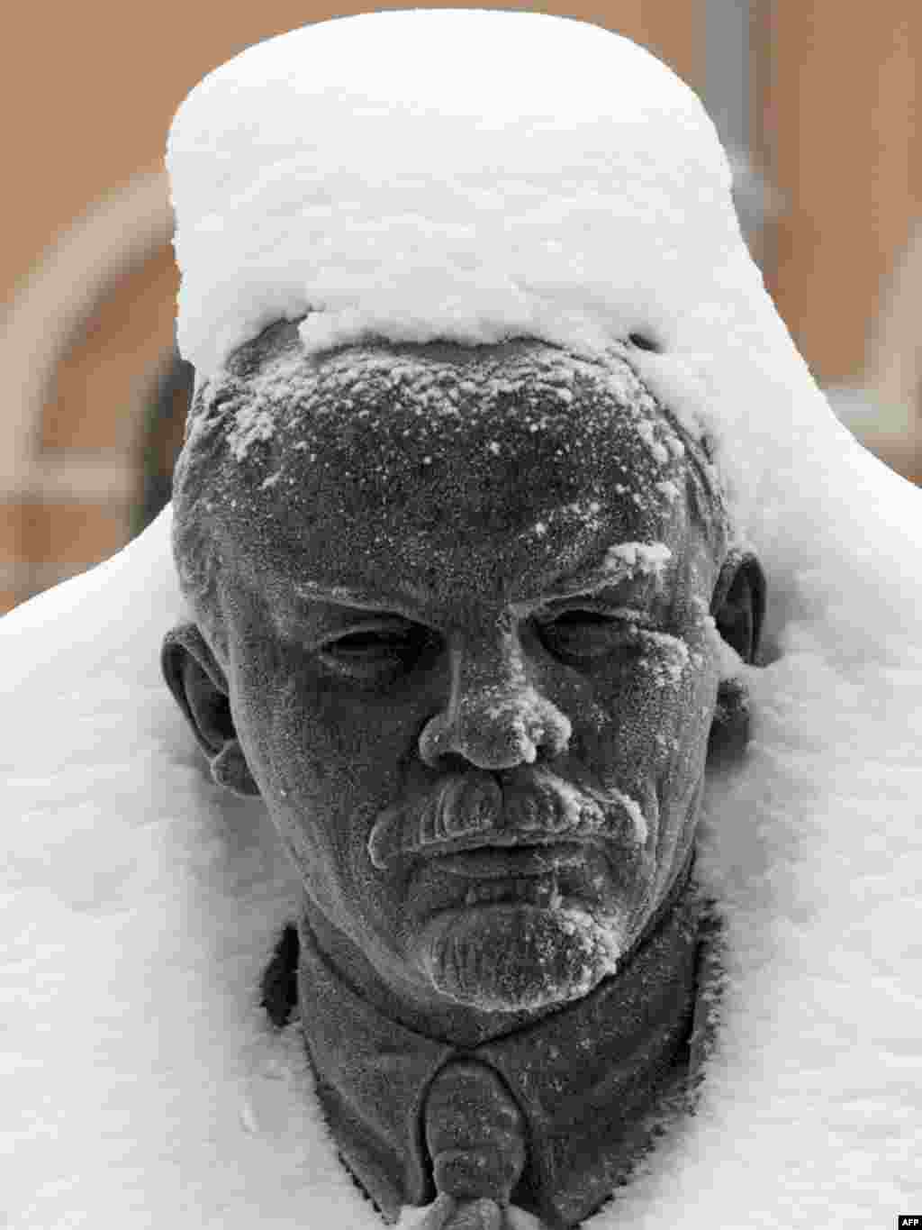 A statue of Vladimir Lenin is covered in snow in St. Petersburg. - Photo by Kirill Kudryavtsev for AFP