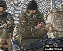 Японський військовий «косплеєр» зі значком українського підрозділу «Азов» заряджає копії патронів. «Азов» має погану репутацію через звинувачення у зв’язках із неонацизмом