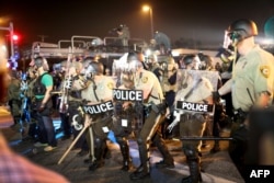 Полицейские во время беспорядков в Фергюсоне. 18 августа 2014 года.