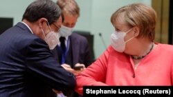 Кипарскиот претседател Никос Анастасиадес и германската канцеларка Ангела Меркел се поздравуваат со допир на лактите на почетокот на Самитот на ЕУ во Брисел за справување со последиците од коронавирусот. 17.7.2020. 
