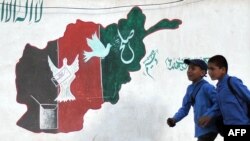 Afghanistan -- Schoolboys walk past a mural of painted with the colours of the Afghan national flag in Kabul, 21May2012