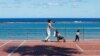 Жінка з дитиною гуляє на набережній пляжу Лас-Кантерас на острові Гран-Канарія, Іспанія, 26 квітня 2020 року