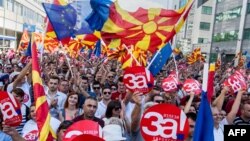Qytetarët valëvisin flamujt e Maqedonisë dhe BE-së, teksa marrin pjesë në një tubim në mbështetje të referendumit të 30 shtatorit.