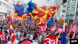 People wave Macedonian and European flags as they attend a campaign rally in Skopje on September 16 for a "yes" vote ahead of a referendum scheduled for later this month.