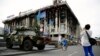 A woman takes a picture of an armoured vehicle left as a monument on Kyiv's Independence Square, known as the "Maidan."