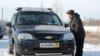 Местный житель у автомобиля с российскими номерами. Актобе, 19 декабря 2014 года.