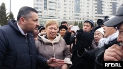 Директор департамента по защите прав потребителей Национального банка Казахстана Александр Терентьев (слева) разговаривает с заемщиками проблемных ипотечных кредитов. Астана, 7 апреля 2015 года. Иллюстративное фото.