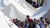 Syrian refugees gather around Turkish Foreign Minister Ahmet Davutoglu (center) during his visit to the Turkish Red Crescent camp in the Yayladagi district of the Turkish city of Hatay on June 15.