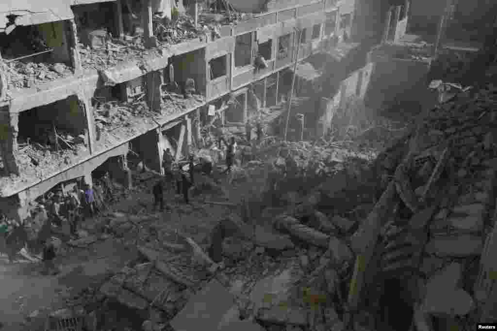 Residents inspect the damage after what Syrian activists say were four air strikes by government forces in Douma, near Damascus. (Reuters/Bassam Khabieh)