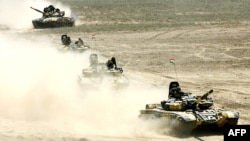 TRussian-built tanks roll under Tajik flags during Peace Mission 2012 joint counterterrorism military exercises of the troops from the six countries in the Shanghai Cooperation Organization in Khujand in June 2012.