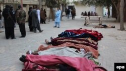 The bodies of the police cadets (covered by blankets) and the body of a suspected militant lay on the ground outside a hospital after an attack by suspected militants at a police training center in Quetta on October 25.