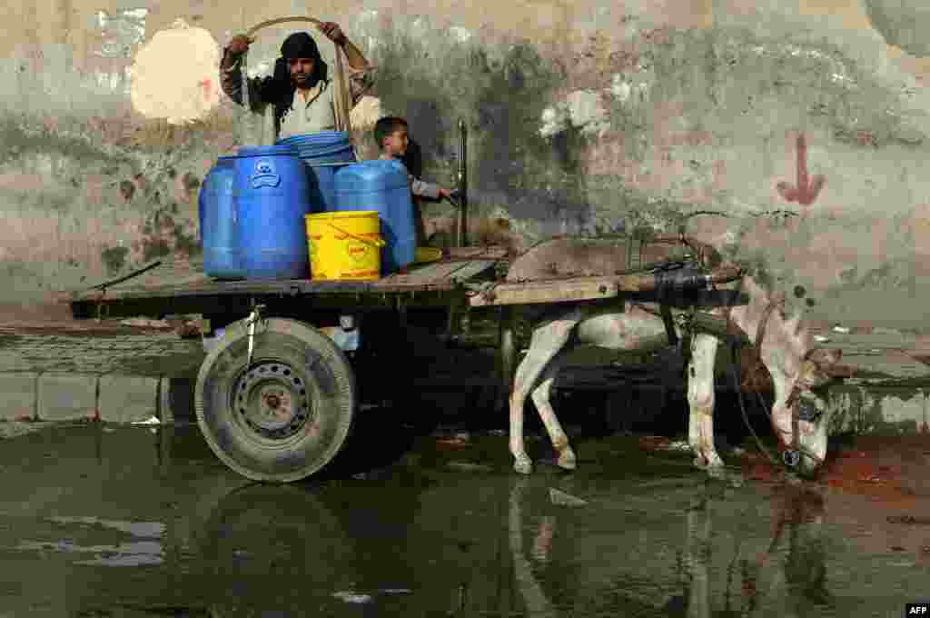 A Pakistani man fills cans with water from a roadside tap during a hot day in Lahore. (AFP/Arif Ali)