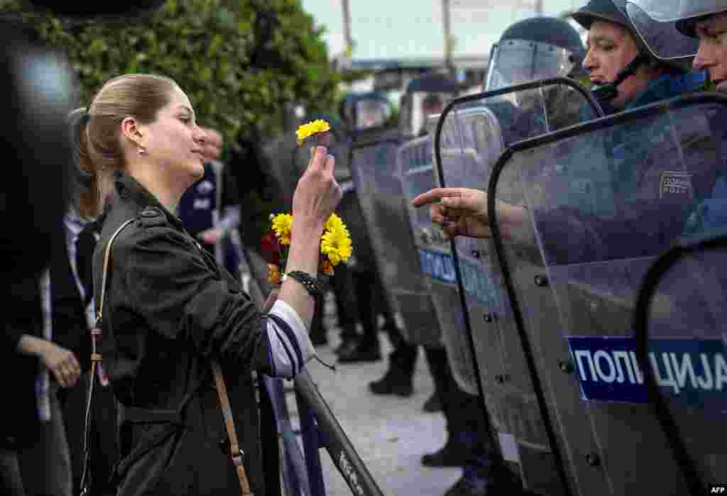 A girl gives flowers to riot-police officers in Skopje on April 15. (AFP/Robert Atanasovski)