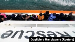 Afrički migranti čekaju na prijevoz sa broda Aquarius do Catanije, Sicilija