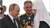Russian Patriarch Kirill, shown on right, is seen as a close adviser of President Vladimir Putin, shown on left. Former Defense Minister Sergei Shoigu is seen here in the middle. 