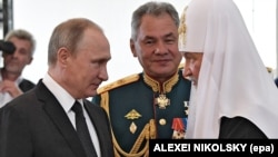 Russian Patriarch Kirill, shown on right, is seen as a close adviser of President Vladimir Putin, shown on left. Former Defense Minister Sergei Shoigu is seen here in the middle. 