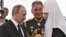 Russian Patriarch Kirill, shown on right, is seen as a close adviser of President Vladimir Putin, shown on left. Former Defense Minister Sergei Shoigu is seen here in the middle. 