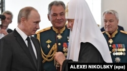 Слева направо: российский президент Владимир Путин, министр обороны России Сергей Шойгу и Московский патриарх Кирилл. Санкт-Петербург, 30 июля 2017 года