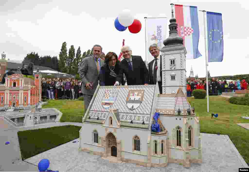 Croatian President Ivo Josipovic (second from right); his wife, Tatiana; Zagreb's Mayor Milan Bandic (left); and Mini-Europe director Thierry Meeus (right) pose next to a miniature of St. Mark's Church in Zagreb after its inauguration at Mini-Europe in Brussels. Croatia is set to become the EU's 28th member in July.