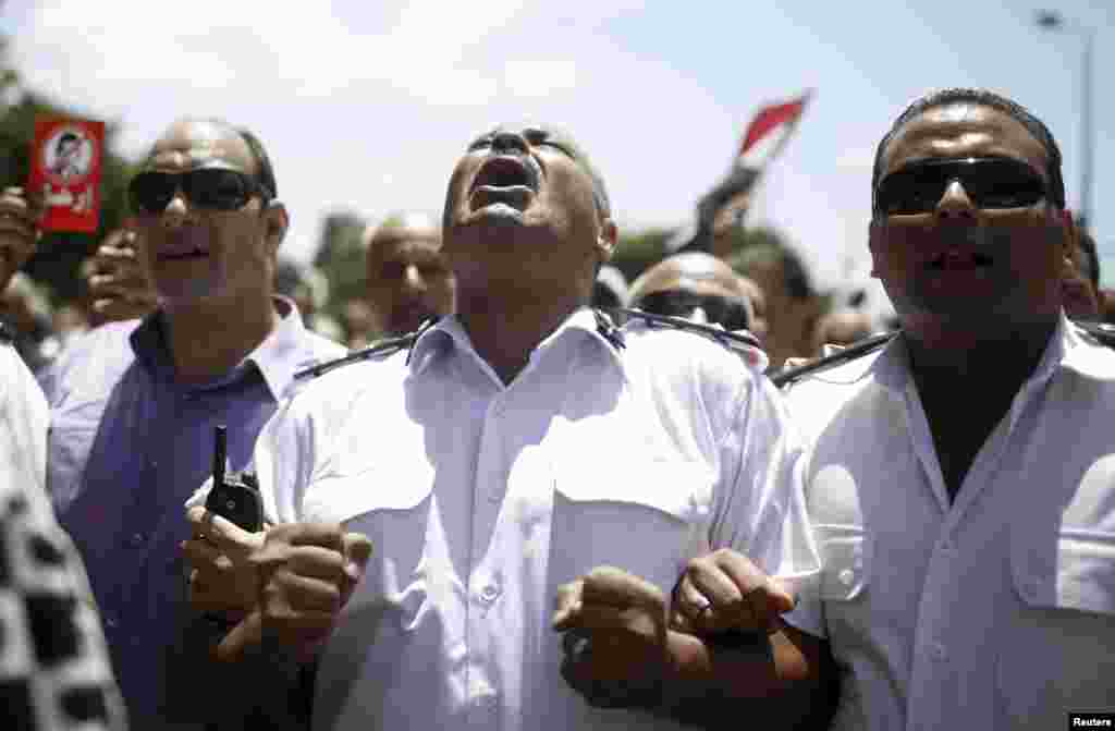 A police officer shouts 'Leave' during an anti-Morsi protest with other police officers and protesters after attending the funeral of Brigadier General Mohamed Hani, a senior police officer from Alexandria, in Alexandria.