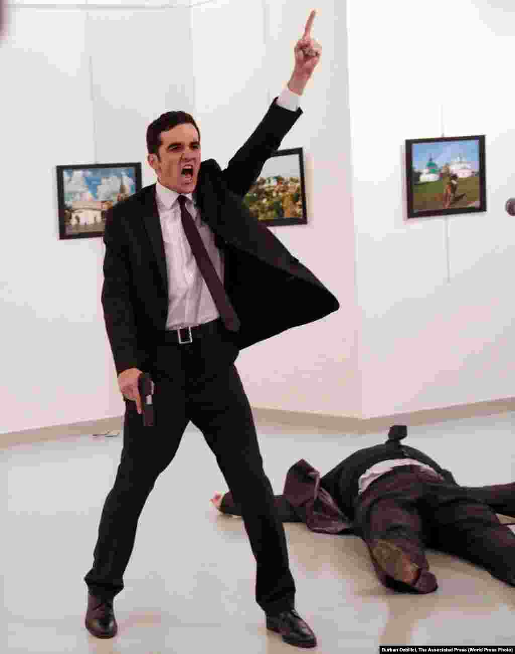 Mevlut Mert Altintas shouts after shooting Andrei Karlov, the Russian ambassador to Turkey, at an art gallery in Ankara, Turkey, December 19, 2016. The winning World Press Photo Of The Year, from Burhan Ozbilici of Associated Press, was also part of a series, &quot;An Assassination in Turkey&quot;, which won the Spot News - Stories category. Ozbilici captured the moments before and after Altintas, an off-duty policeman, drew a handgun and shot Karlov at a photo exhibition. &nbsp;