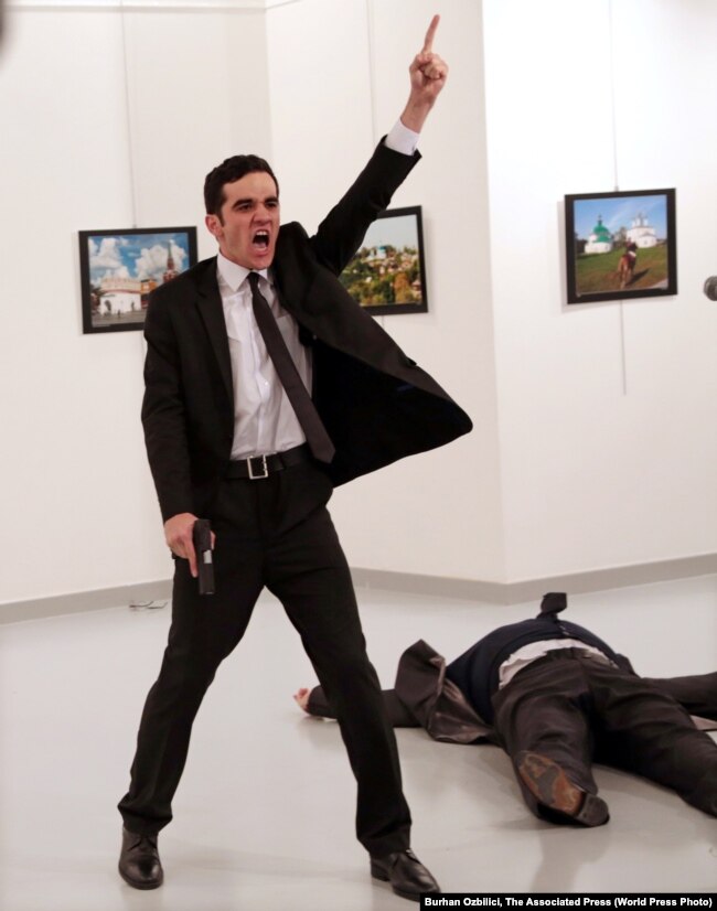 Mevlut Mert Altintas duke bërtitur pasi ka qëlluar me armë zjarri ambasadorin rus në Turqi, Andrei Karlov. Fotoreporteri Ozbilici ka fotografuar Altintasin para dhe pasi ka shtënë mbi ambasadorin Karlov, i cili ishte duke mbajtur një fjalim në një galeri arti. 