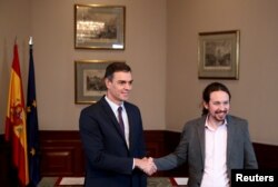 Premijer Pedro Sančes i čelnik Podemosa Pablo Iglesias rukuju se tokom konferencije za novinare u španskom parlamentu u Madridu, Španjolska, 12. novembra 2019.