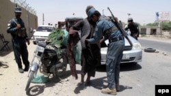 An Afghan security officer frisks a man at a checkpoint in Helmand on June 25.