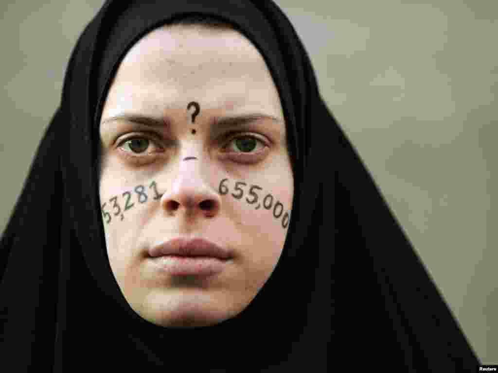 Alicia Casilio, dressed as an Iraqi civilian, stands silently at an anti-Iraq war protest in Boston, Massachusetts January 11, 2007. The numbers on Casilio's face represent the estimated number of Iraqi civilians killed in the war. REUTERS/Brian Snyder