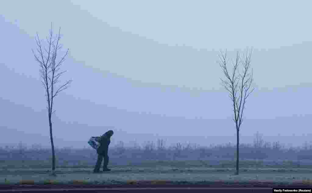 A man carries his belongings during heavy fog in Minsk, Belarus. (Reuters/Vasily Fedosenko)