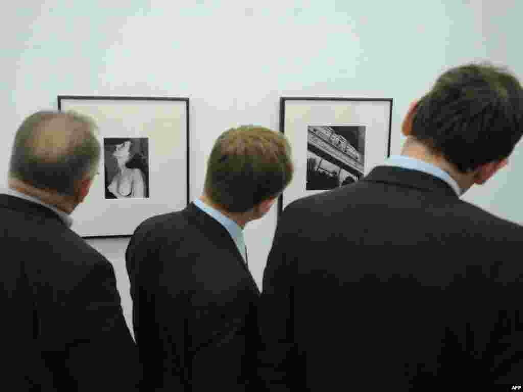 Rusija - Tri čovjeka i fotografija - Kamera fotoreportera je zabilježila trenutak kada su tri Moskovljana pažljivo posmatrala istu fotografiju.