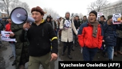 Активист Улан Усойун (слева) во время акции протеста против коррупции в Бишкеке. 25 ноября 2019 года.