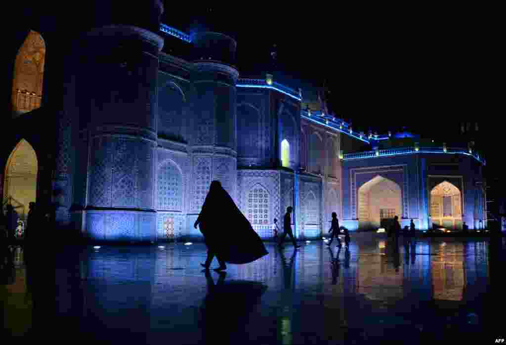 An Afghan woman walks in the courtyard of the Hazrat-e Ali shrine, or "Blue Mosque" in the northern city of Mazar-e Sharif. (AFP/Farshad Usyan)