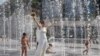 A bride walks in a fountain on a hot summer day in Kyiv, where temperatures reached over 36 degrees Celsius. (epa/Sergey Dolzehnko)
