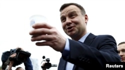 Оппозиционный кандидат Анджей Дуда предлагает прохожим кофе – на следующий день после голосования 10 мая