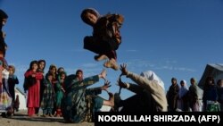 FILE: In this photograph taken on December 23, 2017 Afghan school children play at an open-air school at the Gambiri Refugee Camp in Laghman province.