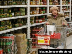 A woman pushes a shopping cart as she visits a food store in Moscow. (file photo)