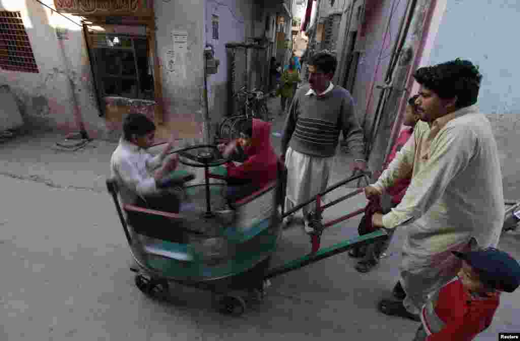 Pakistani children ride on a makeshift merry-go-round in a slum in Islamabad. (Reuters/Faisal Mahmood)